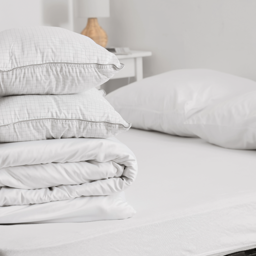 Clean bedding folded on a bed, creating a calm and restful environment after baby loss